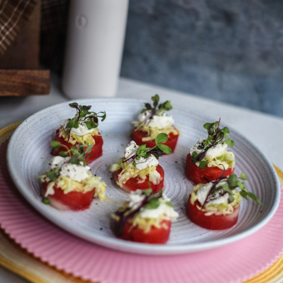 watermelon appy's on a white plate with a dark green and blue background