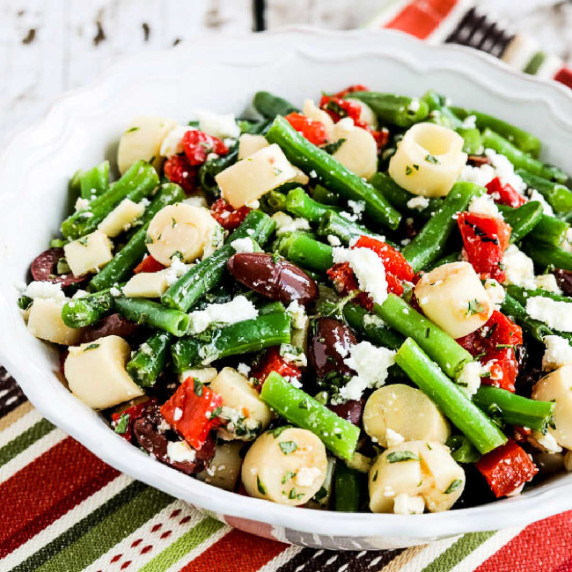 Green Bean Salad with Hearts of Palm shown in serving bowl on striped napkin.