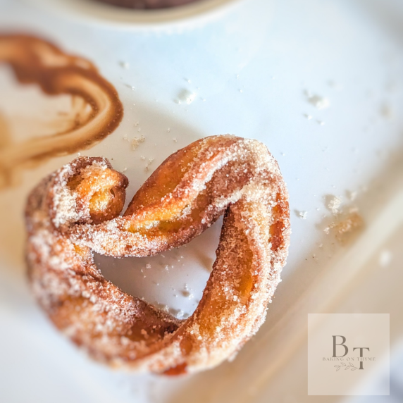 Churro in the shape of a heart on a white plate 