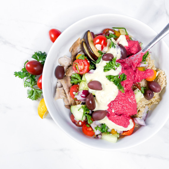 Mediterranean Grain Bowls with beet hummus in a white bowl.