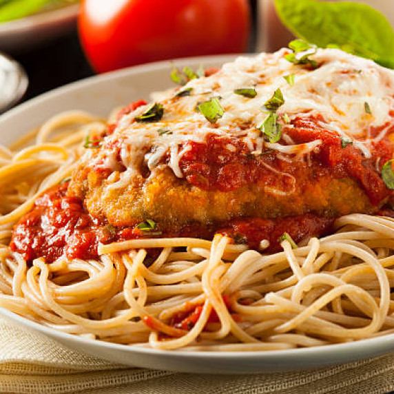 Chicken parmesan served over pasta 