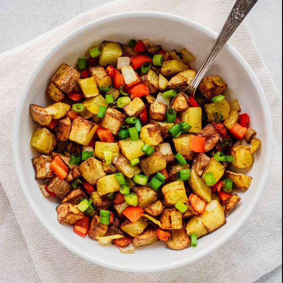 Overhead view of breakfast potatoes on a white bowl