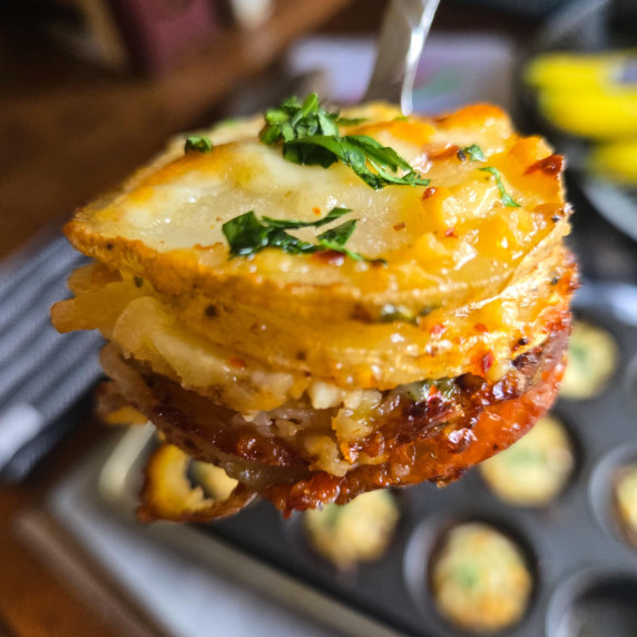 A stack of golden potatoes with fresh green parsley