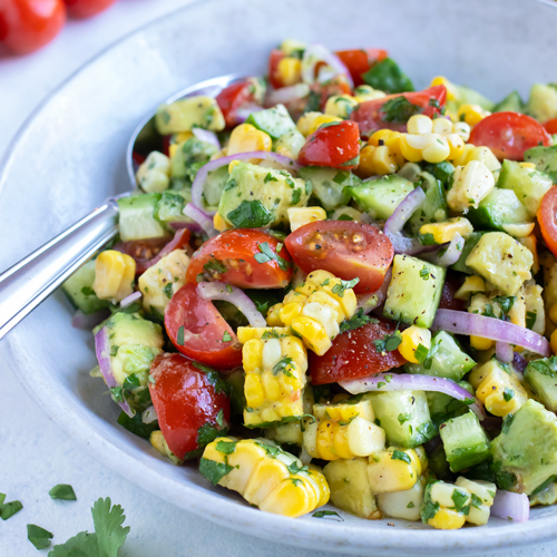Avocado Corn Salad RECIPE served in a white bowl.