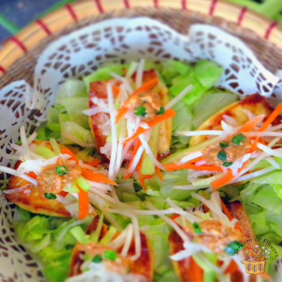 Baked tofu stuffed with beansprouts, carrots, jicama, and cucumber on lettuce with peanut sauce