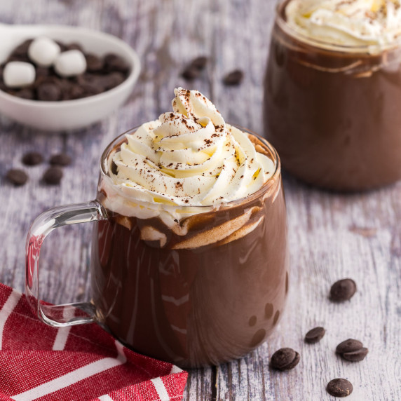 glass mug filled with hot chocolate and whipped cream.