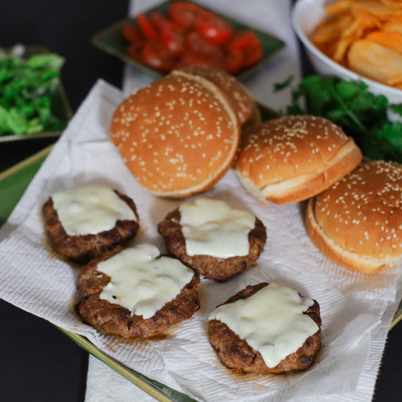 Oven broiled hamburgers on a platter with all the fixings on burger night.