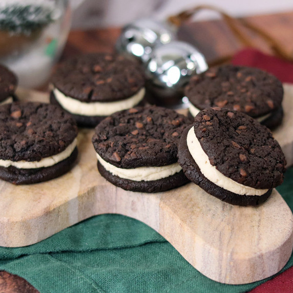 Black and white espresso sandwich cookies on a Christmas plate with white background