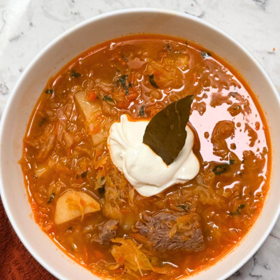 Bowl of homemade borscht soup garnished with sour cream and parsley