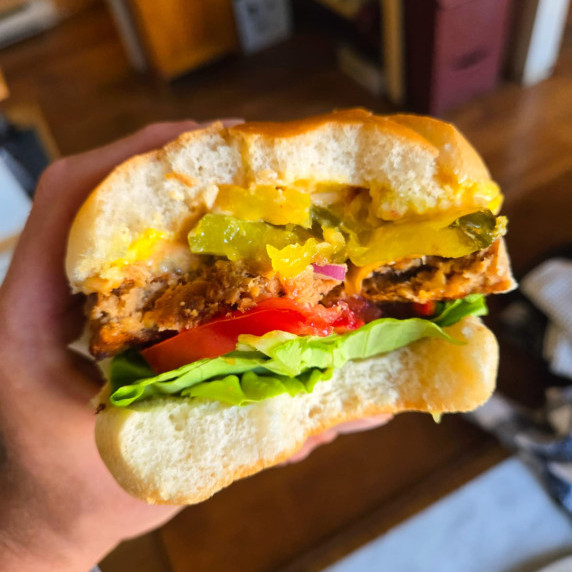 A juicy vegetarian burger with pops of green, red and yellow from toppings.