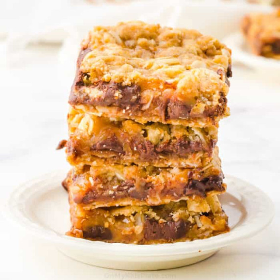 Square image stacked caramel chocolate oat bars.