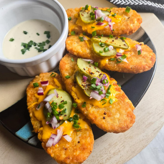 Golden hashbrowns with cheese, green pickles, and red onions with creamy Ranch