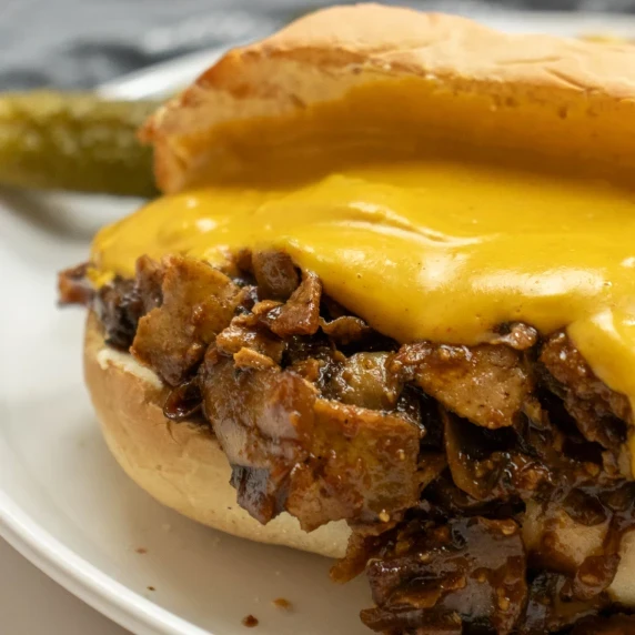 Close up shot of vegan philly cheesesteak with vegan cheese sauce on top
