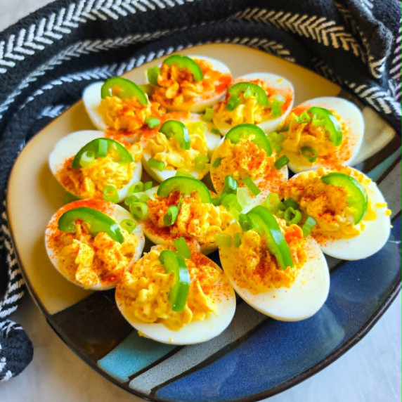 Golden filling piped into eggs topped with green onions, jalapeno and chili