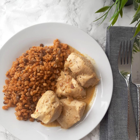 A plate with large chunks or chicken breast brined and cooked with spices and sour cream. 