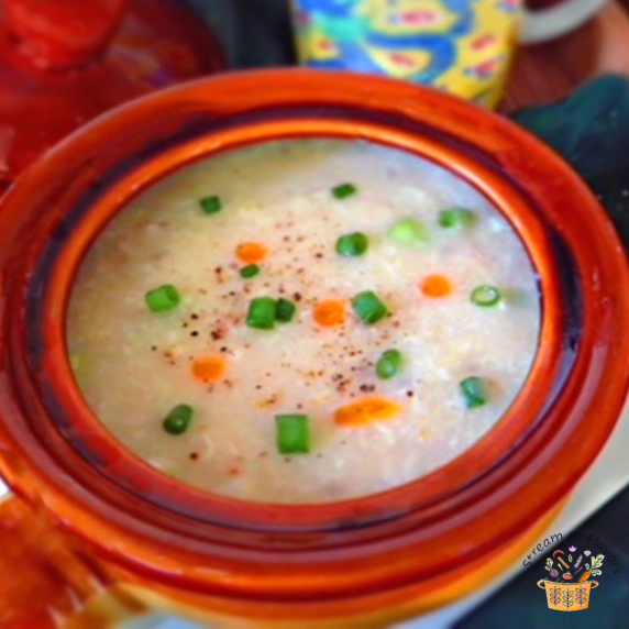 Chinese Chicken Corn Soup in an orange bowl with creamed corn, shredded chicken, and soy sauce