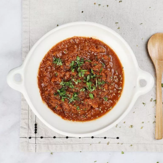 Salsa de chipotle is made with pan-roasted tomatoes, onion and garlic in white plate.