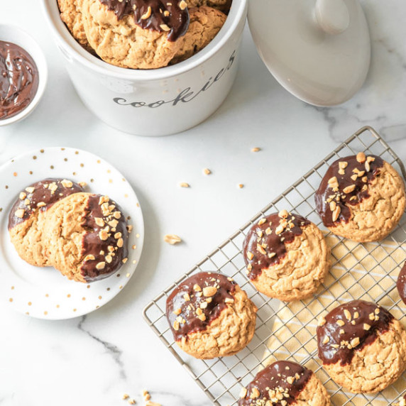 Peanut butter cookies dipped in milk chocolate on a cooling rack