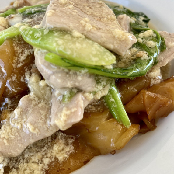 Close-up of rad na (Thai noodles with pork gravy).