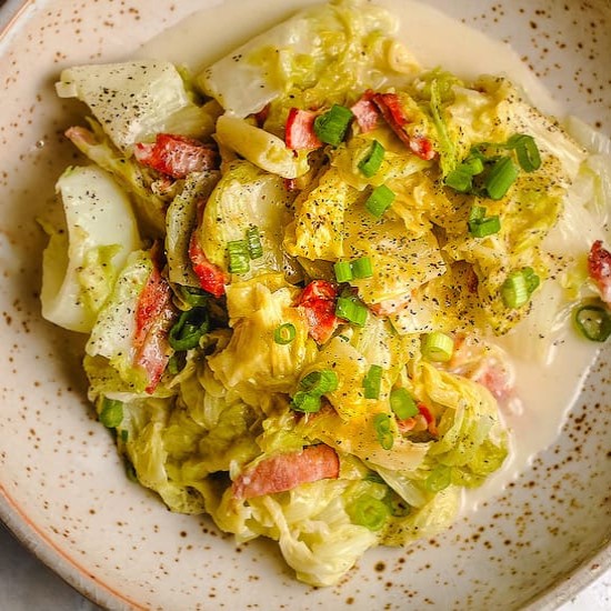 Napa cabbage, green onions and bacon on a stoneware plate