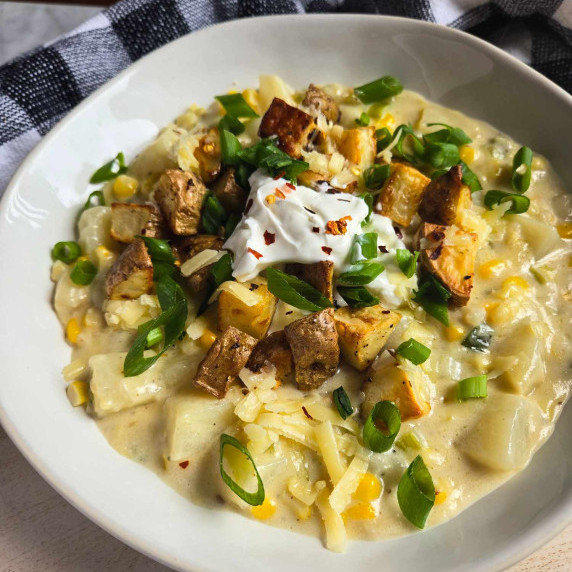 Creamy chowder topped with golden brown potatoes, white sour cream, green onions, and shredded ched