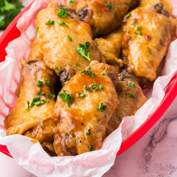 A red basket filled with BBQ chicken wings.