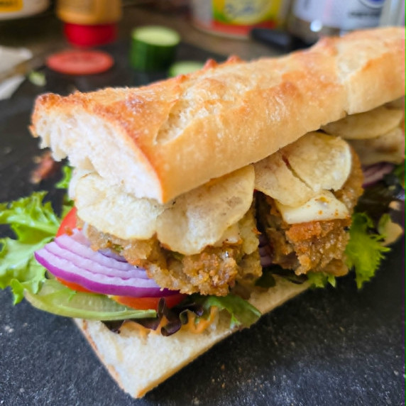 Golden baguette filled with colourful veggies and golden potato chips.