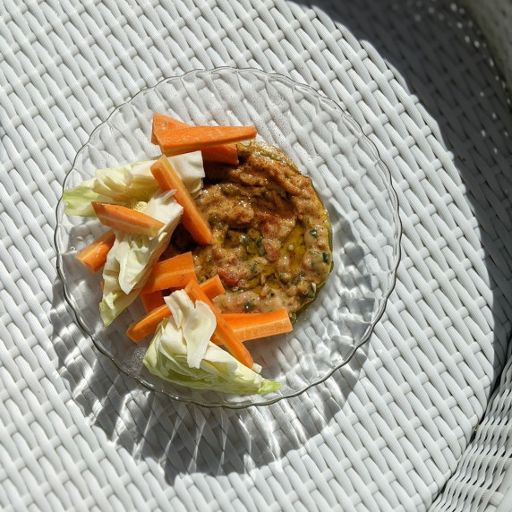 Vegan bean dip in a bowl with veggies on a floating pool tray