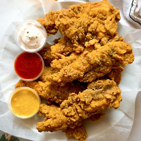 Buttermilk Fried Chicken Tenders in a plate with three dips next to them.