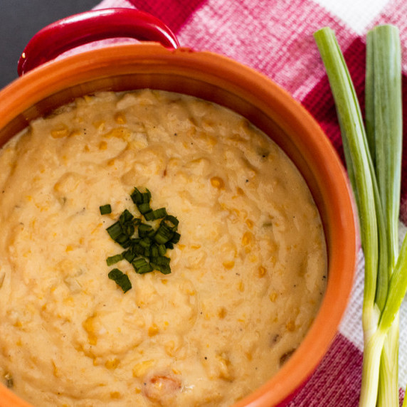 Creamy Corn Chowder in a crock next to some fresh chives.