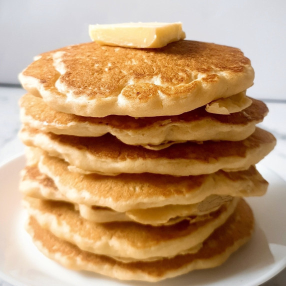 Fluffy pancakes stacked over a white plate.