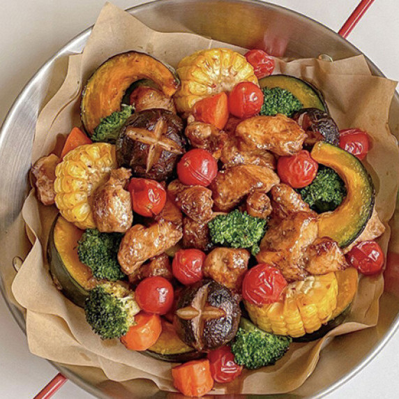 Corn, zucchini, tomato, broccoli, corn, chicken on top of dry absorbent paper