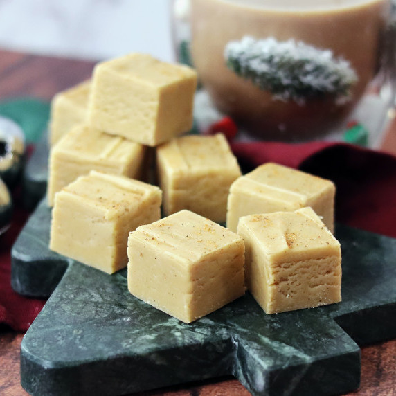 Brown sugar eggnog fudge arranged on a holiday plate against a white background.