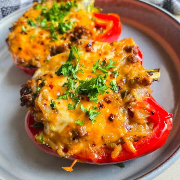 Bright red peppers stuffed and baked under melty cheese with green parsley.