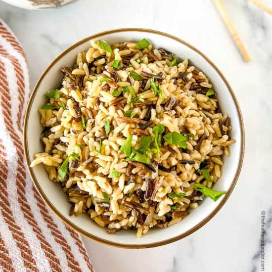 A plate of Instant Pot Wild Rice with dish cloth on the side.