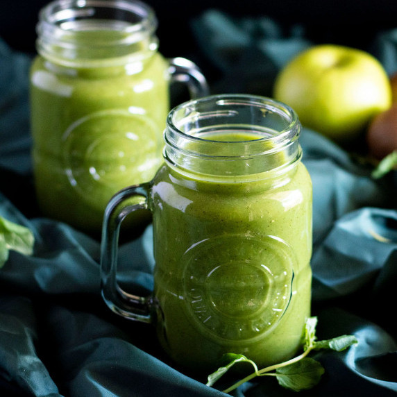 Two mason jars full of fresh kiwi juice.
