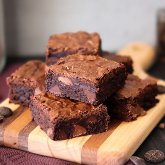 Three brownies on a slate platter against a white background