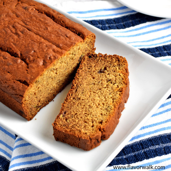 Gluten free peanut butter banana bread and a slice of the bread on a white rectangular plate.