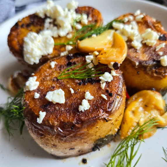 Golden potatoes with crumbled white feta and pops of green dill.