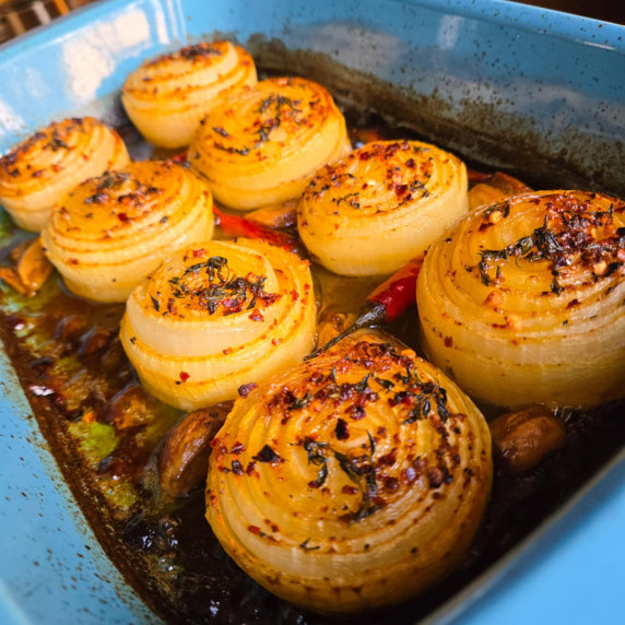 Golden brown baked onions in a blue baking dish.