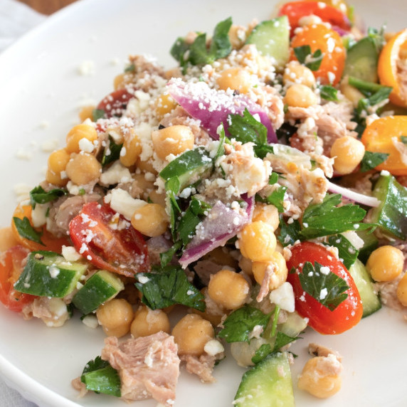 Greek Tuna Salad on a white plate with feta cheese garnish