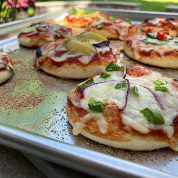 Miniature pizzas baked on a sheet pan.
