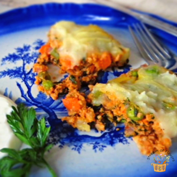 Ground chicken shepherd's pie with vegetables and sour cream on a blue plate with a fork