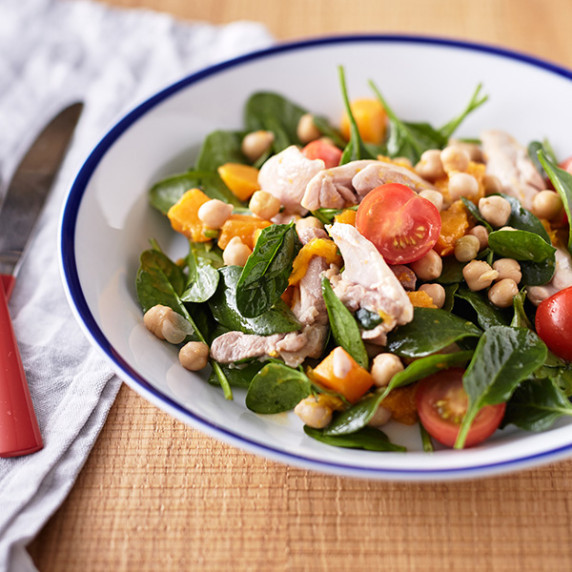 Vibrant bowl of roasted pumpkin salad featuring chicken, cherry tomatoes, chickpeas, and pumpkin