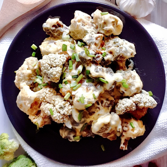 Homemade Batter Fried Broccoli with Creamy Sauce on a black plate.