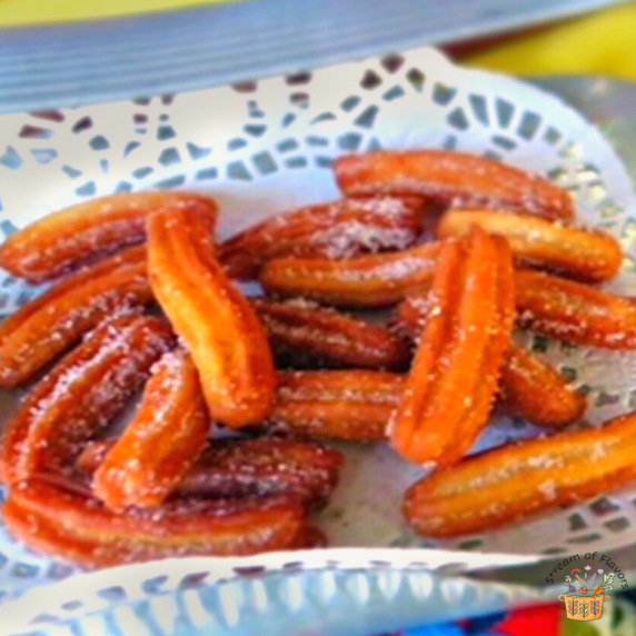 Homemade Churros with flour, butter, eggs, and cinnamon sugar on a metal plate