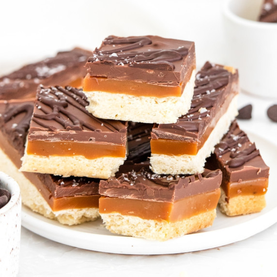 Layered dessert bars stacked on a plate.