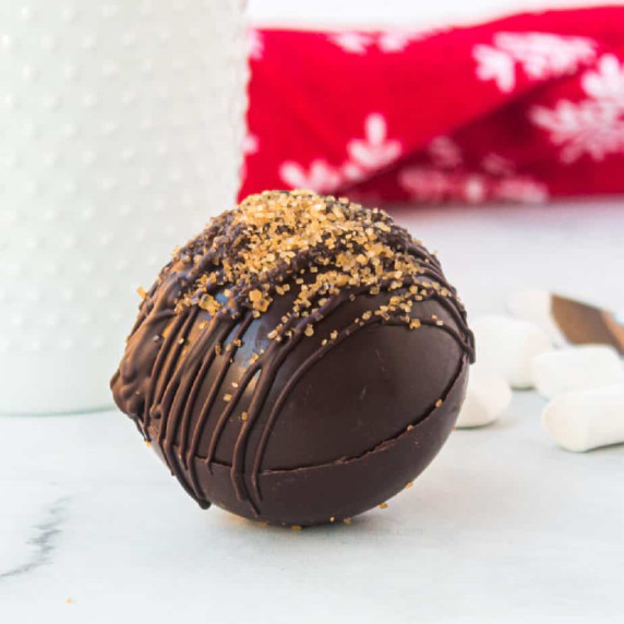 Close up of a hot cocoa bomb topped with raw cane sugar.