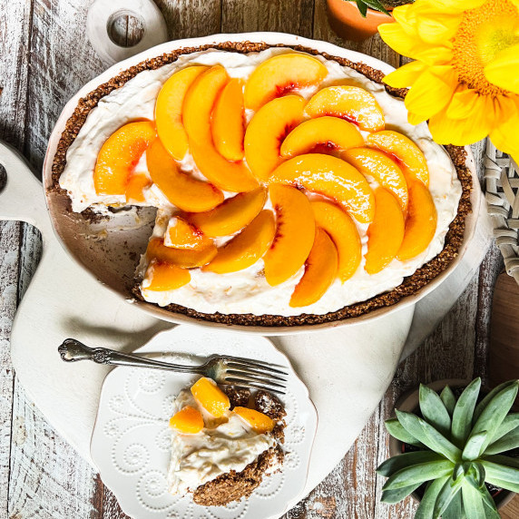 peach covered gluten-free pecan crust dessert with a piece sitting to the side
