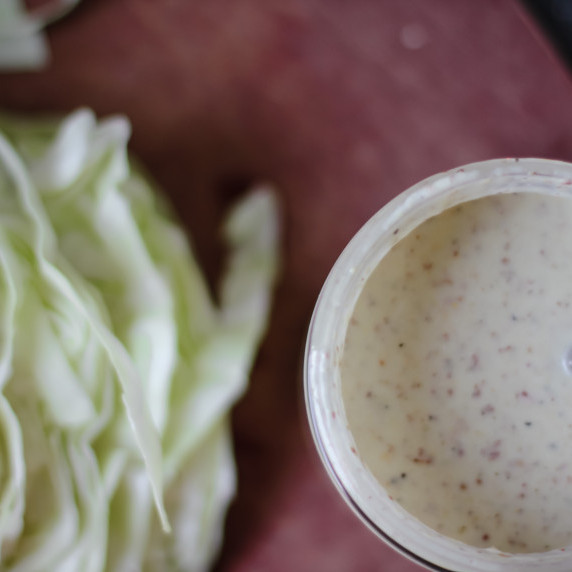 Creamy salad dressing in a small glass jar 